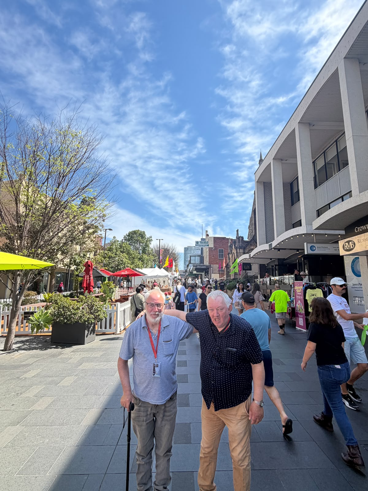 Two people smiling together on a sunny community outing